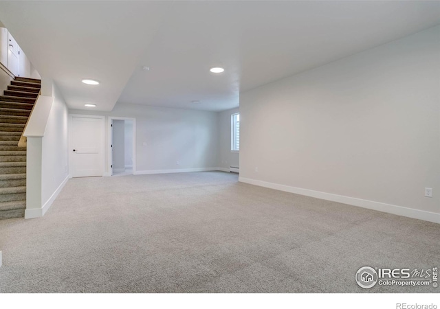 carpeted spare room with a baseboard radiator