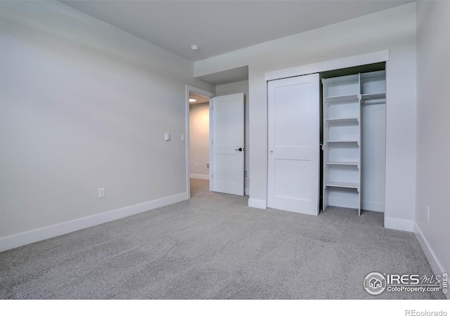 unfurnished bedroom with light colored carpet and a closet