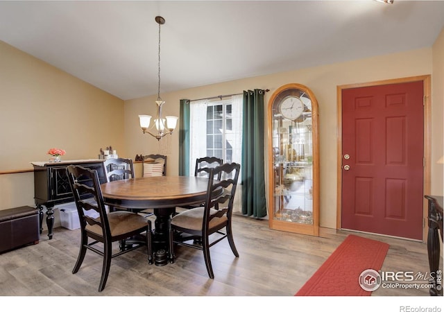 dining space featuring light hardwood / wood-style flooring and a notable chandelier