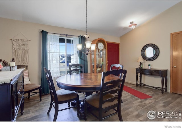 dining area featuring dark hardwood / wood-style flooring and an inviting chandelier