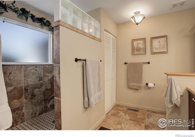 bathroom featuring a shower and vanity