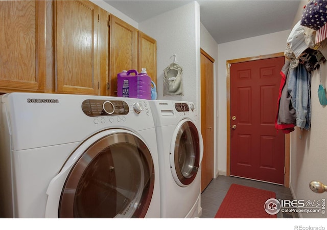 washroom with cabinets and washing machine and clothes dryer