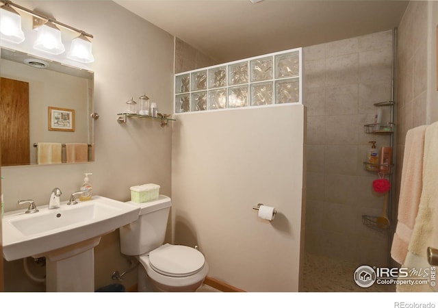 bathroom with toilet and a tile shower