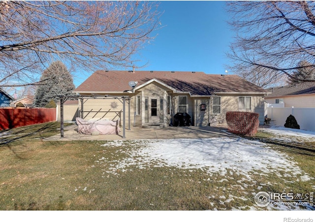 snow covered house with a yard and a patio