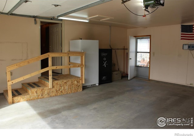 garage with a garage door opener and freestanding refrigerator