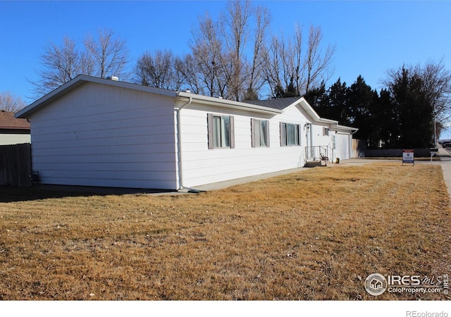 view of side of home with a lawn and a garage