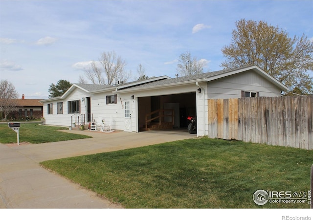 view of front of house with fence, driveway, a front yard, and a garage