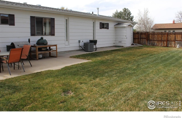 back of house with fence, a lawn, a patio area, and central AC