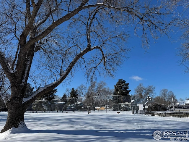 yard covered in snow with tennis court