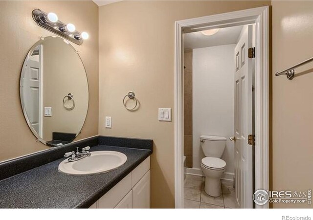 bathroom with vanity, tile patterned floors, and toilet