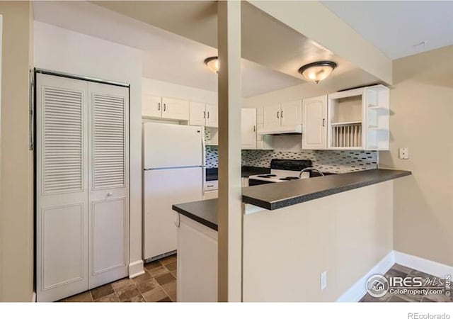 kitchen with electric range oven, tasteful backsplash, white cabinets, kitchen peninsula, and white fridge