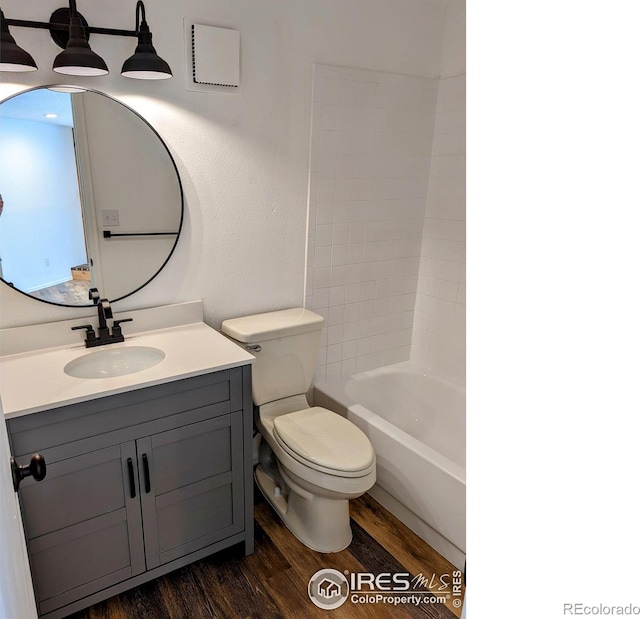 full bathroom with bathtub / shower combination, vanity, toilet, and hardwood / wood-style floors