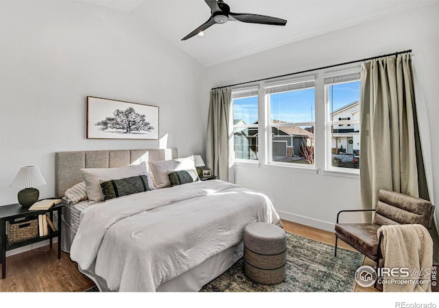 bedroom with ceiling fan, dark hardwood / wood-style floors, and lofted ceiling