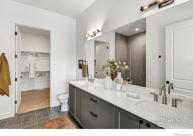 bathroom featuring an enclosed shower, vanity, and toilet