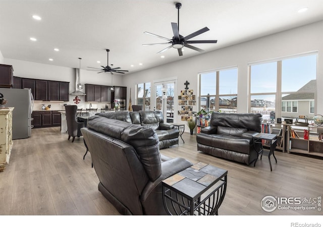 living room with ceiling fan and light hardwood / wood-style floors