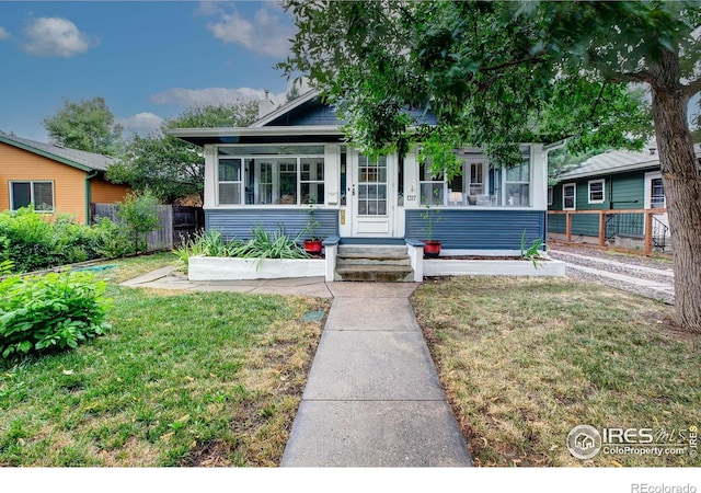 view of front of property featuring a front lawn and a sunroom