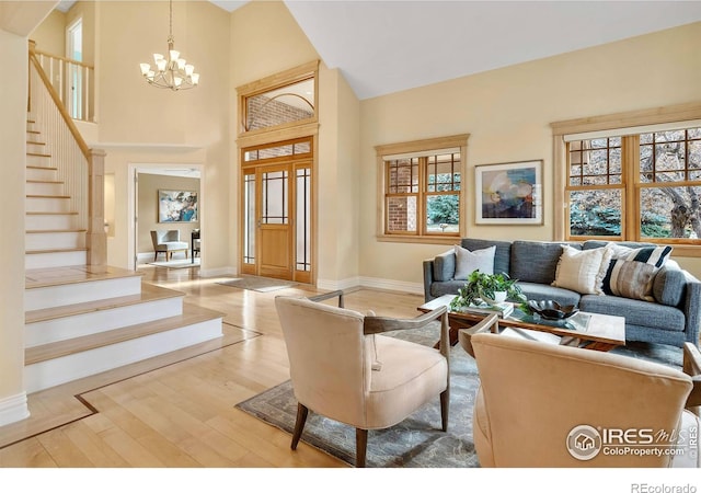 6345 Swallow Ln, Boulder, CO 80303 - living area with stairway, light wood-style floors, a chandelier, and a high ceiling