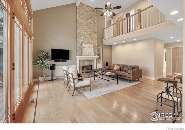 6345 Swallow Ln, Boulder, CO 80303 - living area featuring high vaulted ceiling, light wood-style floors, a stone fireplace, a ceiling fan, and beamed ceiling