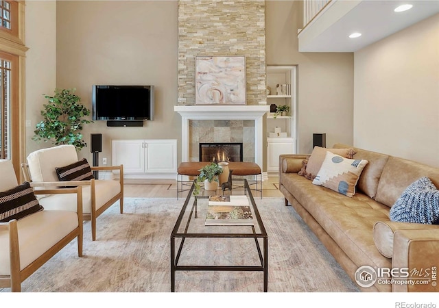 6345 Swallow Ln, Boulder, CO 80303 - living area featuring a tiled fireplace, wood finished floors, recessed lighting, a high ceiling, and built in features