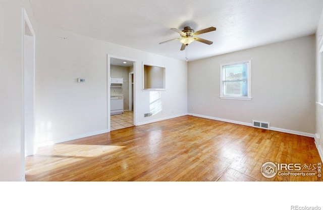 empty room with ceiling fan and light hardwood / wood-style flooring