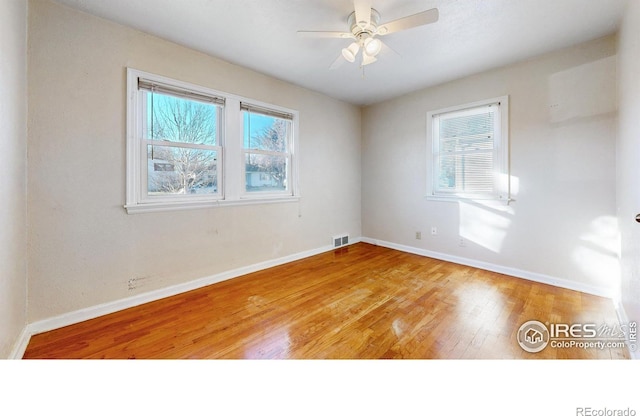 empty room with ceiling fan and hardwood / wood-style floors