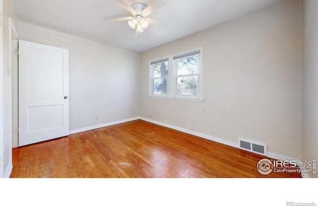 empty room with ceiling fan and hardwood / wood-style flooring