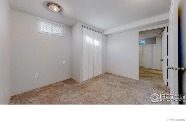 unfurnished bedroom featuring a closet and light colored carpet