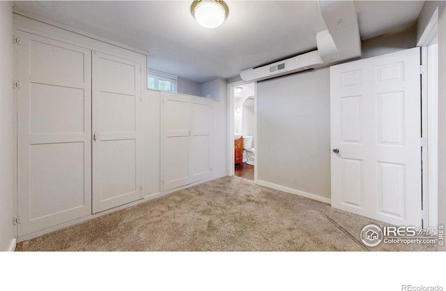 unfurnished bedroom with light colored carpet and a closet