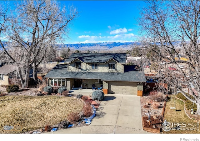 view of front of property featuring a mountain view, a front yard, and a garage