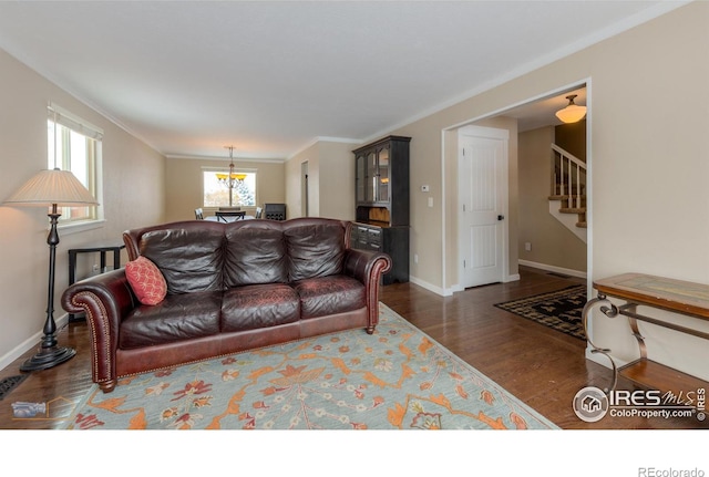 living room with dark wood-type flooring and ornamental molding