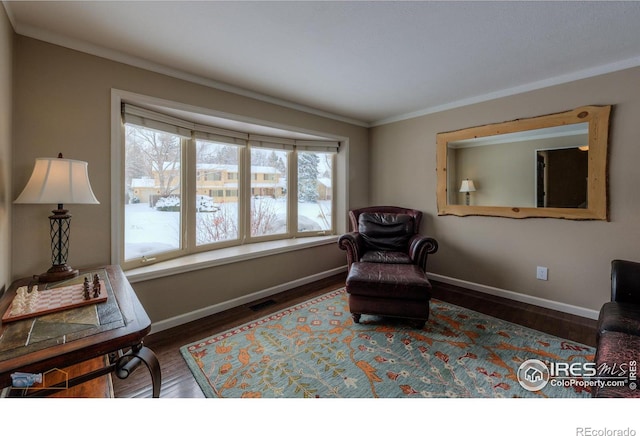 sitting room featuring dark wood-type flooring and crown molding