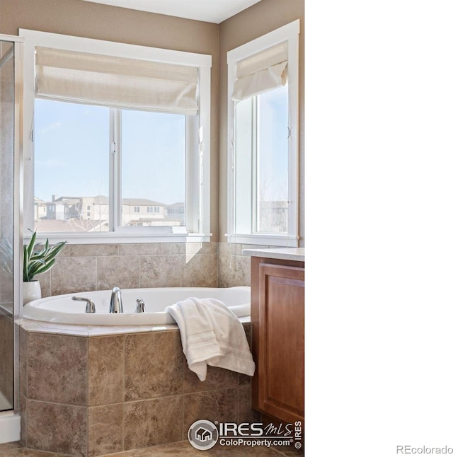 bathroom with a relaxing tiled tub