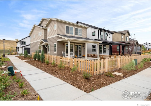 view of front of house with a fenced front yard, a residential view, and a porch