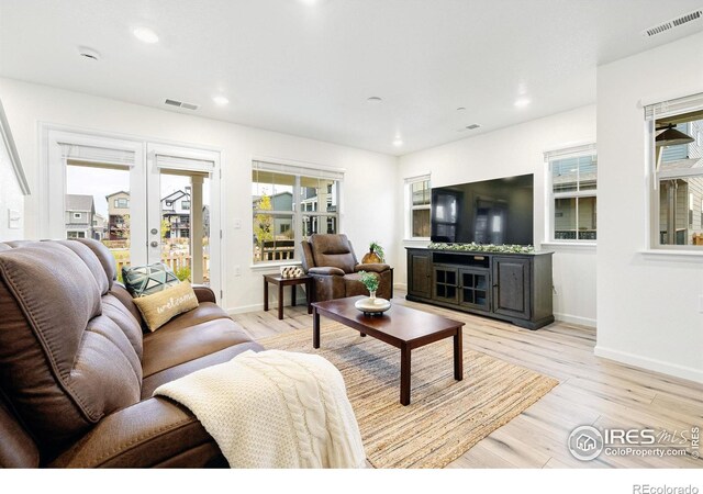 living room featuring light wood-type flooring, french doors, visible vents, and recessed lighting