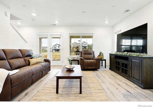 living room with light wood-type flooring, visible vents, and recessed lighting