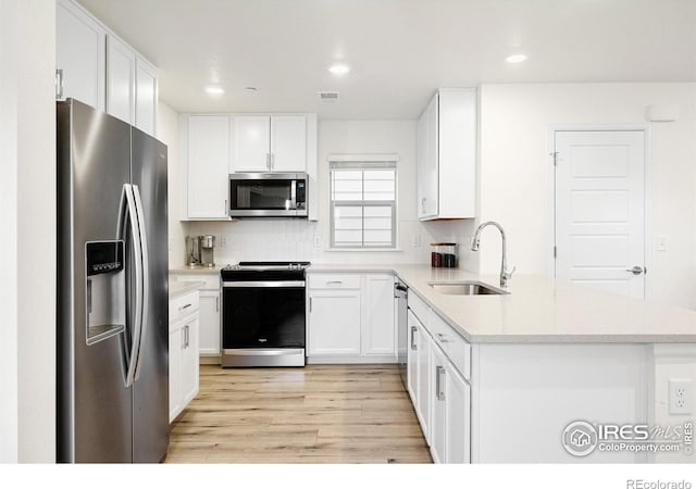 kitchen featuring stainless steel appliances, light countertops, and white cabinetry