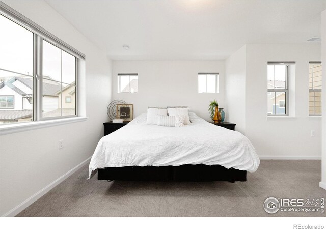 bedroom featuring baseboards and light colored carpet