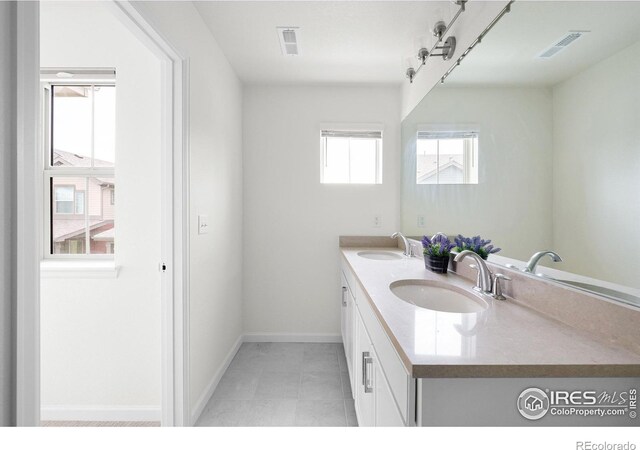 full bath with double vanity, a sink, and visible vents