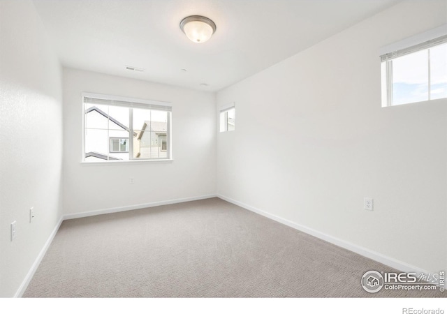 carpeted empty room with visible vents and baseboards