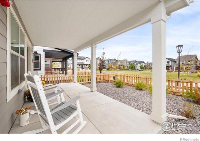 view of patio featuring a residential view and fence