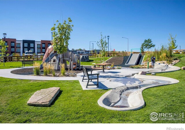 view of playground with a yard and fence