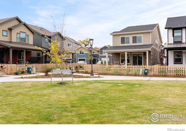 view of front of property with a front lawn, a fenced front yard, and a residential view