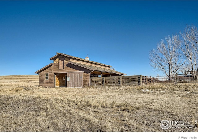 rear view of house with an outbuilding and a rural view