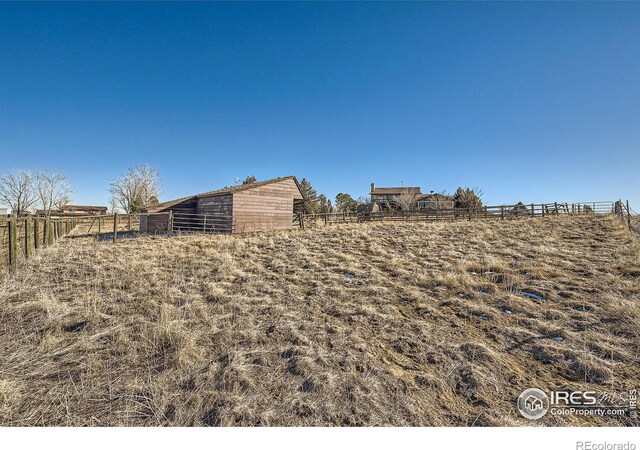 view of yard with a rural view and an outdoor structure