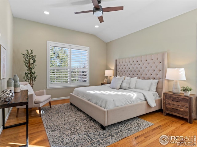 bedroom with ceiling fan, light hardwood / wood-style floors, and lofted ceiling