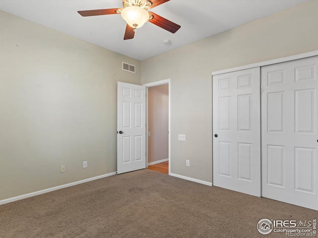 unfurnished bedroom featuring ceiling fan, a closet, and carpet flooring