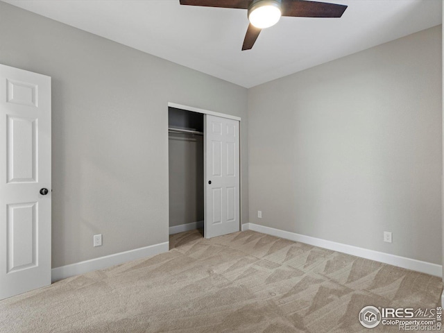 unfurnished bedroom featuring ceiling fan, light colored carpet, and a closet