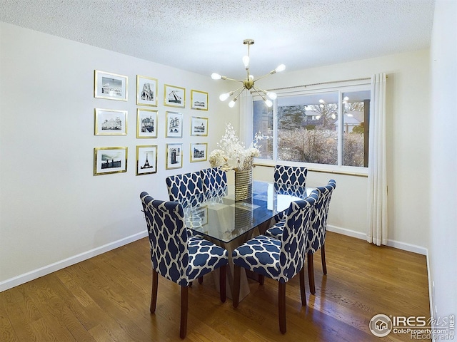 dining space with an inviting chandelier, wood finished floors, baseboards, and a textured ceiling