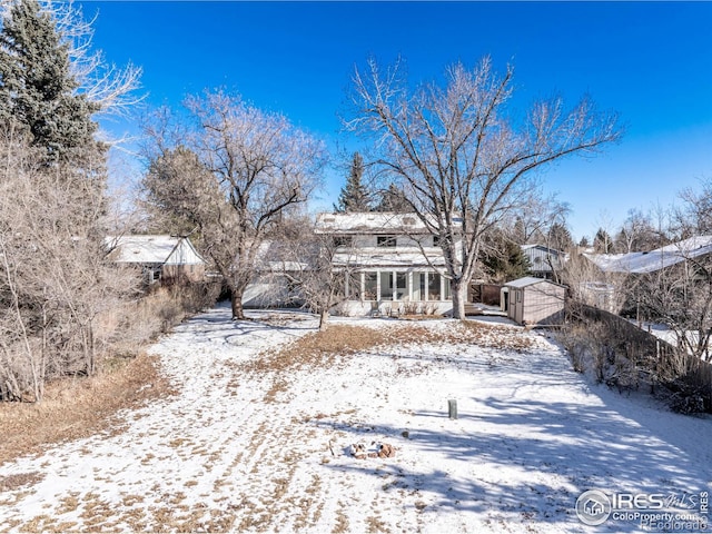 snow covered property with an outbuilding