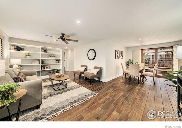 living room with ceiling fan and dark hardwood / wood-style flooring